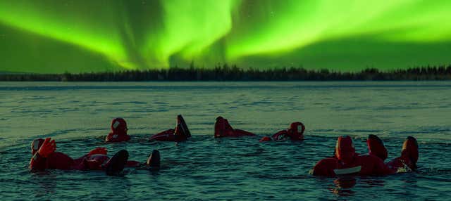 Bagno in un lago ghiacciato sotto l'aurora boreale