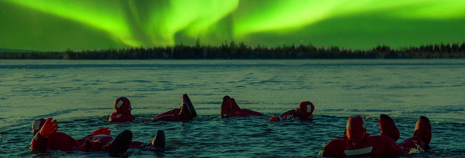 Bagno in un lago ghiacciato sotto l'aurora boreale
